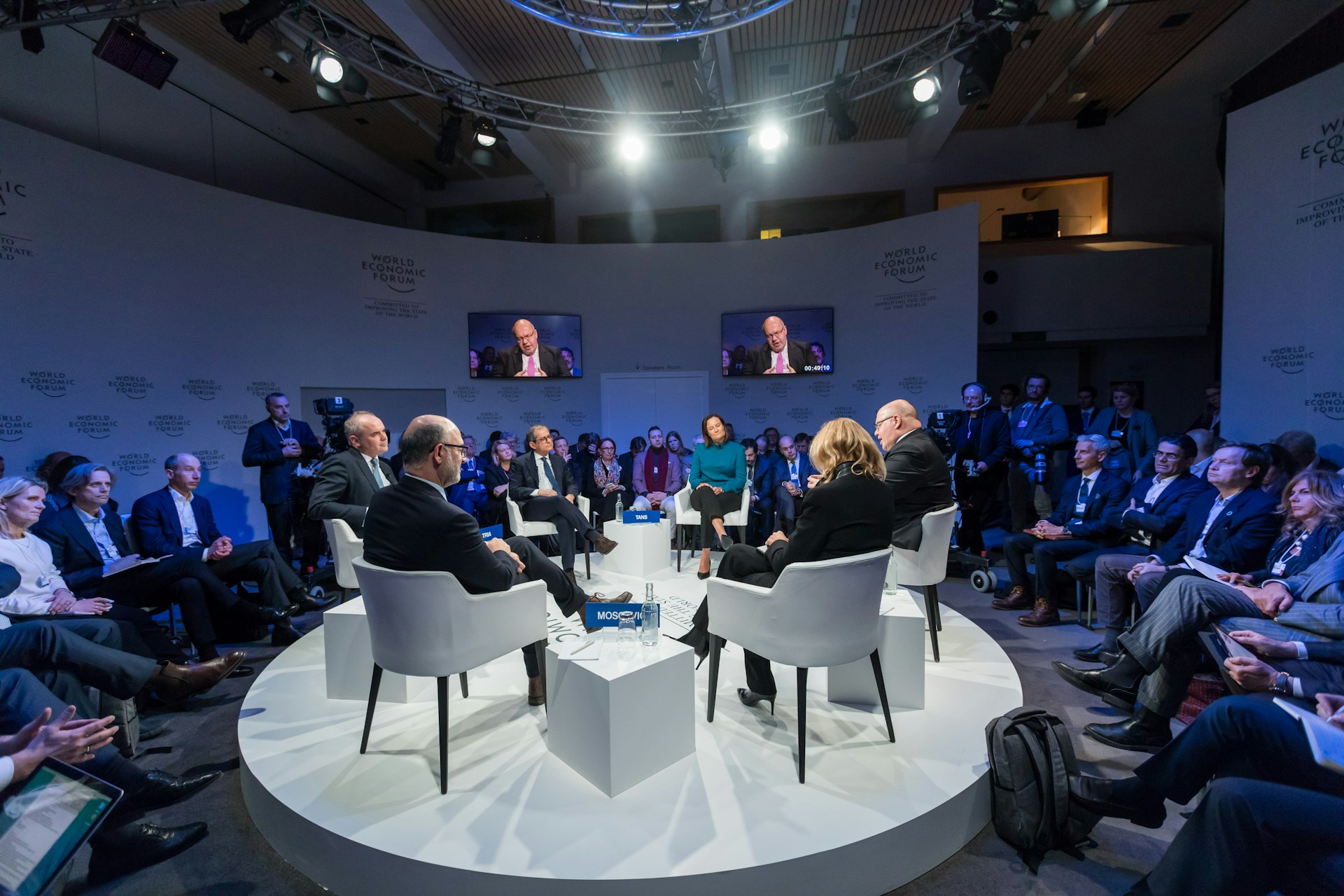 Delegates seated in the round during a panel discussion at a conference