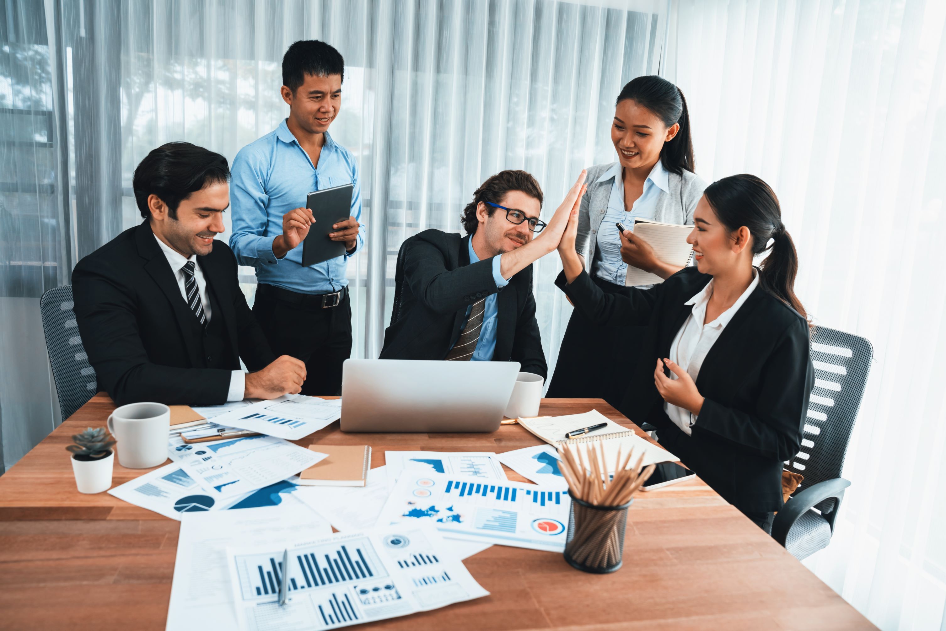 Colleagues collaborating over printed reports at a desk