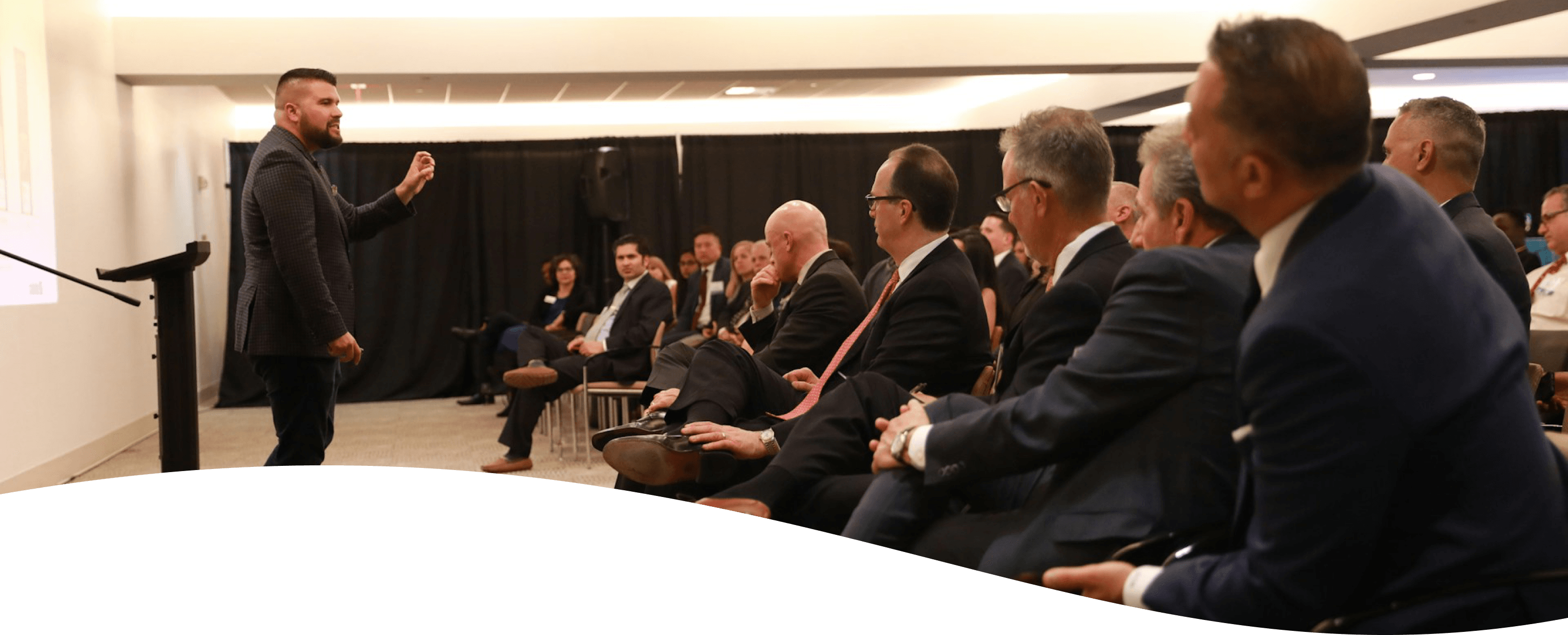 Speaker addressing a seated audience at a corporate event