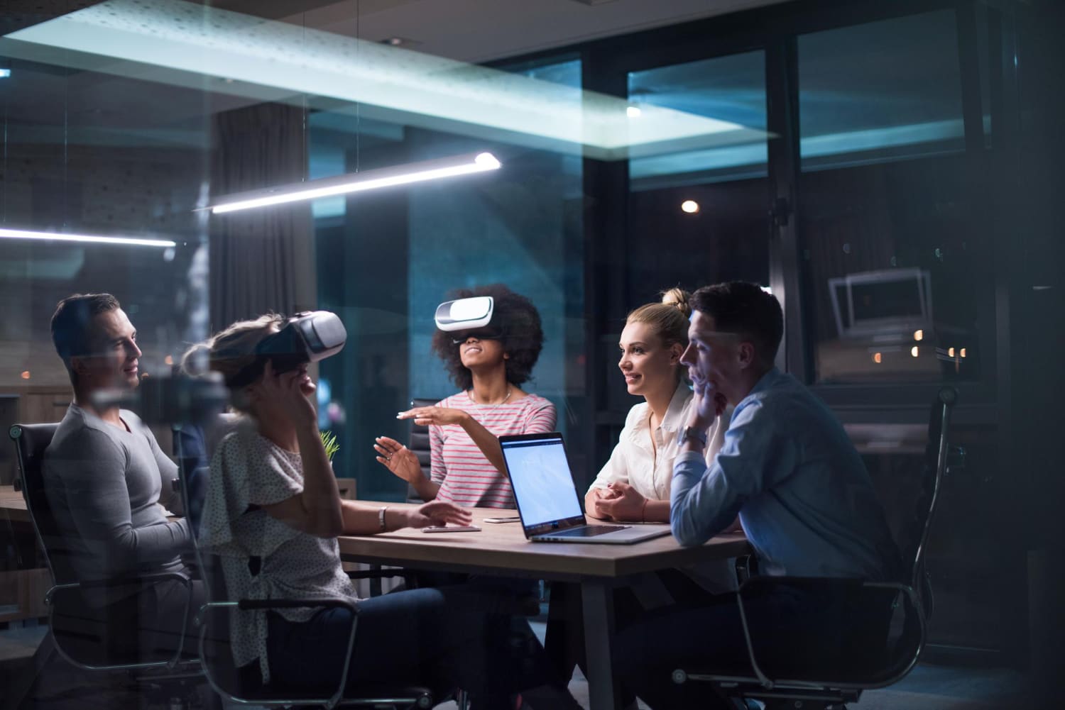 Colleagues in a meeting room trying VR headsets together during a demo